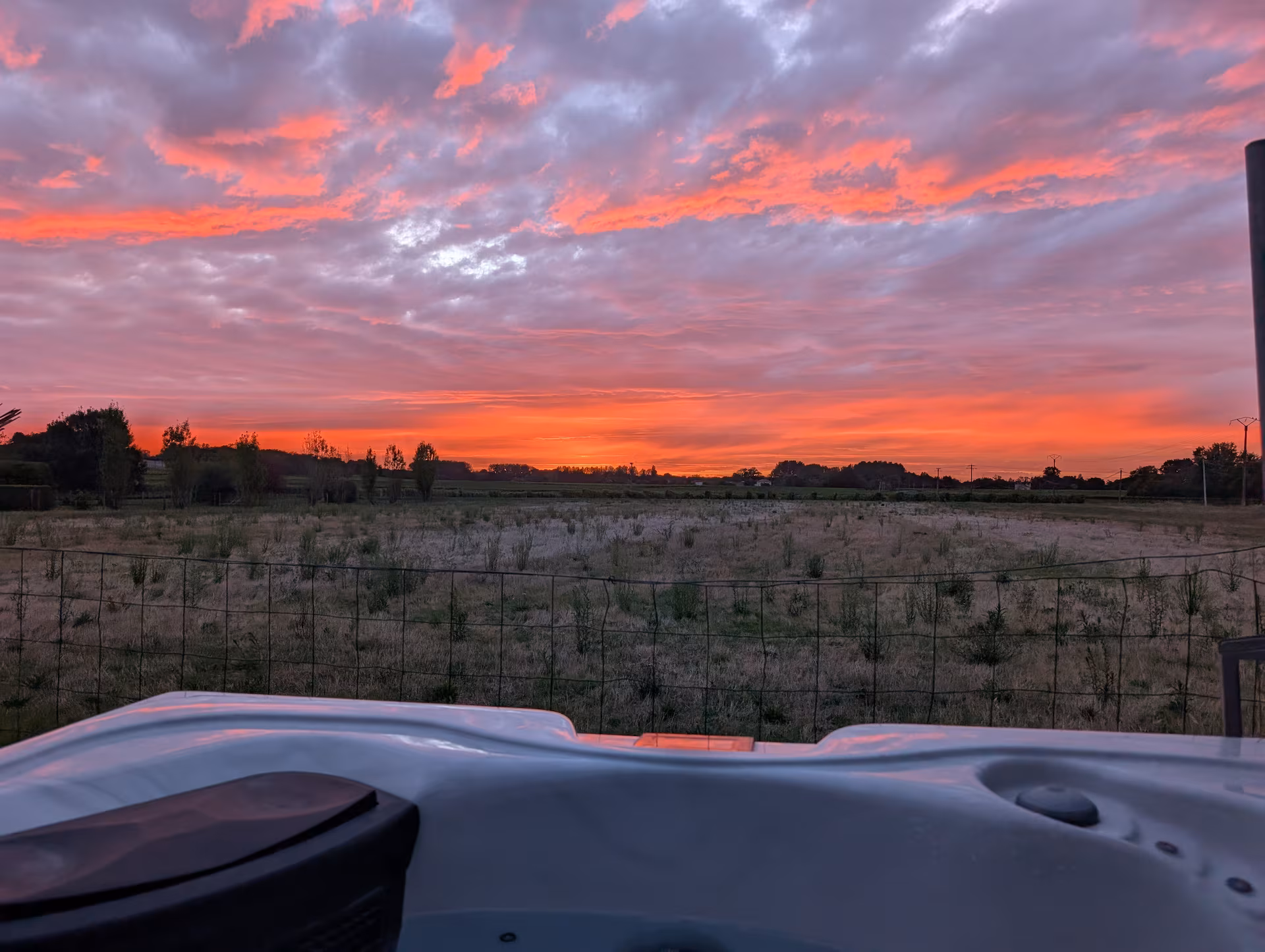 Tiny house en bois au coucher du soleil sur sa terrasse, en Charente